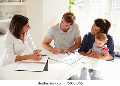 Family With Baby Meeting Financial Advisor At Home