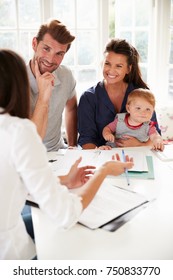 Family With Baby Meeting Financial Advisor At Home