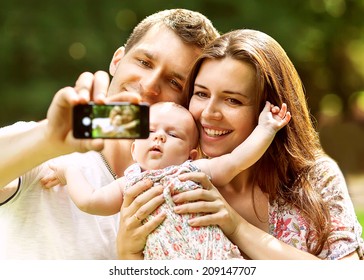  Family With Baby In Park  Taking Selfie By Mobile Phone