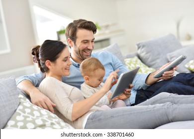 Family With Baby In Sofa Watching Tv 