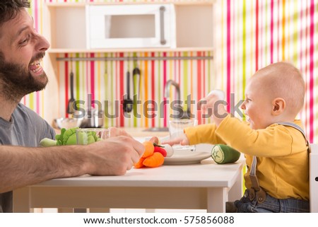 Family Baby Son And Dad Play Eat Meal In Toy Kitchen Family Baby Son And Dad Play Eat Meal In Toy Kitchen