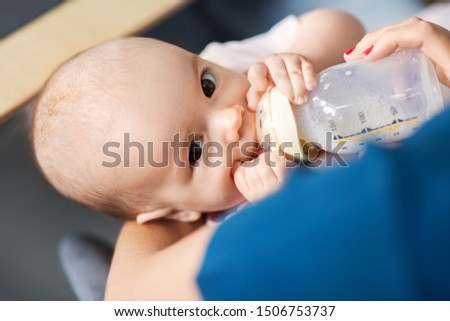 Similar – Image, Stock Photo Mother bottle feeding baby at home