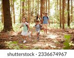 Family With Backpacks Hiking Or Walking Through Woodland Countryside