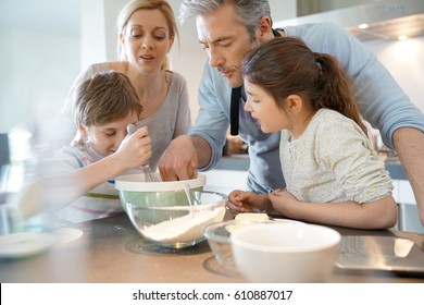 Family Baking Cake Together In Home Kitchen