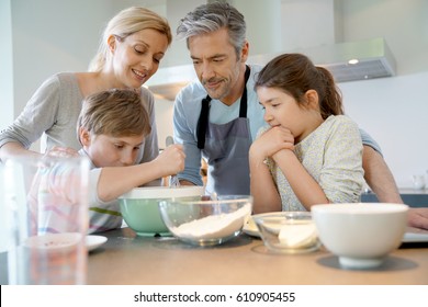 Family Baking Cake Together In Home Kitchen