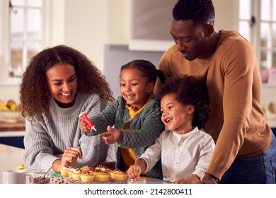 Family Baking Cupcakes Sitting Around Kitchen Counter At Home - Powered by Shutterstock