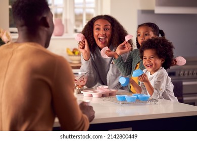 Family Baking Cupcakes Sitting Around Kitchen Counter At Home