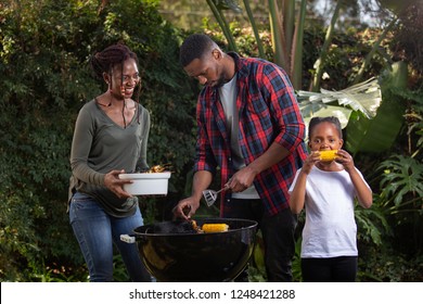 A family barbecuing food together - Shutterstock ID 1248421288