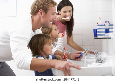 Family In Bathroom Brushing Teeth