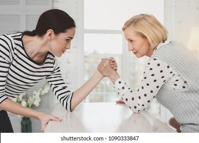 Family Battle. Nice Young Woman Looking At Her Mother In Law While Having A Competition With Her