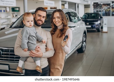 Family With Bbay Girl Choosing A Car In A Car Saloon