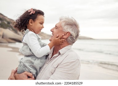 Family, Beach And Bonding With Grandfather And Grandchild Hug, Sharing A Sweet Moment In Nature Together. Young Girl Holding Senior Man, Having Fun, Talking And Enjoying A Day Outdoors At The Ocean