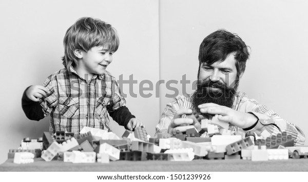 Family is\
Best. small boy with dad playing together. happy family leisure.\
father and son play game. building home with colorful constructor.\
child development. Changing\
responsibilities.