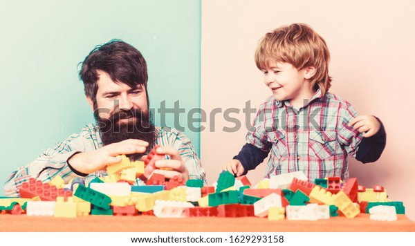 Family is\
Best. small boy with dad playing together. happy family leisure.\
father and son play game. building home with colorful constructor.\
child development. Changing\
responsibilities.