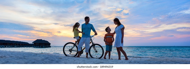 Family With A Bike On Tropical Beach At Sunset