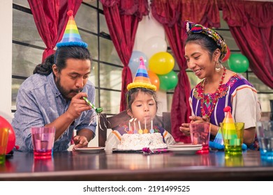 Family At A Birthday Party. Little Girl Blowing Out Candles On Cake. Latin Family Celebrating At Home. Hispanic Family Celebrates A Birthday.