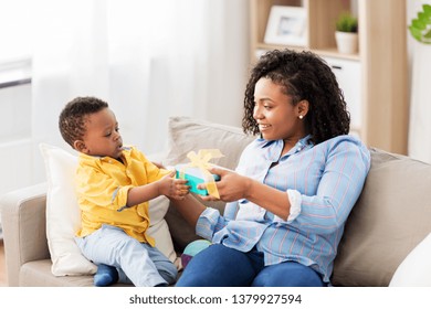 Family, Birthday And People Concept - Happy African American Mother Giving Present To Her Baby Son At Home