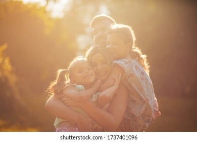 Family Is Bliss. Parents With Daughters Playing In Nature.