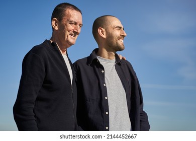 Family Bond Concept. Father And Son Smiling And Looking To The Sky On Sunny Morning