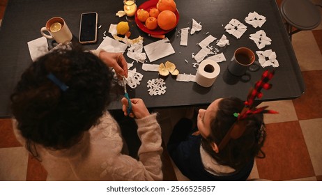 A family bonding activity making holiday crafts showcasing love, warmth, and creativity. Featuring scissors, paper cutouts, and festive items, promoting togetherness during the winter holiday season. - Powered by Shutterstock