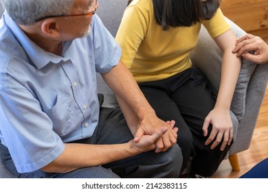 Family bonding. Grandfather and child holding hands together, sit on sofa.