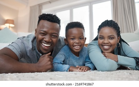 Its Family Bonding Time. Shot Of A Young Couple Lying On The Living Room Floor And Bonding With Their Son At Home.