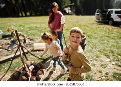 Family Bonfire In Mountain.Four Kids Camping. Bbq Marshmallow. Autumn Hike And Camp Weather. Warming And Cooking Near Flame Together. 