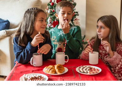 Family Breakfast. Excited Kids in Christmas Attire with Cocoa and Cookies - Powered by Shutterstock