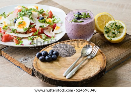 Family breakfast table with chia blueberries smoothie and fresh mixed vegetable salad