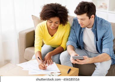 Family Budget, Finances And People Concept - Couple With Papers And Calculator Counting Money At Home