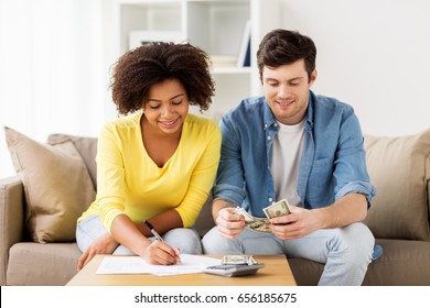 family budget, finances and people concept - happy couple with papers and calculator counting money at home - Powered by Shutterstock