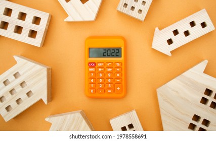 Family budget planning. Investments, plans, savings. Mortgage rates. Real estate concept. Refinance home. Wooden houses and calculator 2022. - Shutterstock ID 1978558691