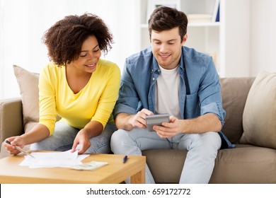 Family Budget, Savings And People Concept - Happy Couple With Papers And Calculator At Home