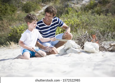 Family Building Campfire On Beach