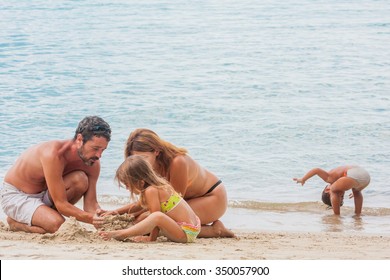 Family Building Sand Castle On Beach