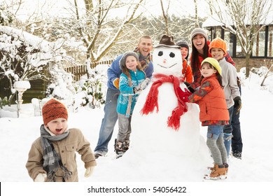 Family Building Snowman In Garden