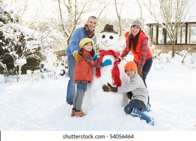 Family Building Snowman In Garden