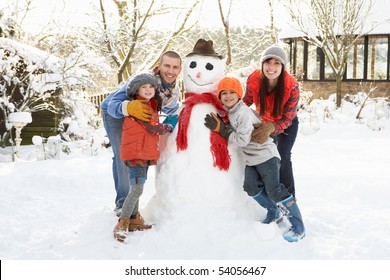 Family Building Snowman In Garden