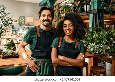 Family business of gardeners. A man and a woman in professional clothes are standing in their own plant shop and smiling. - Powered by Shutterstock