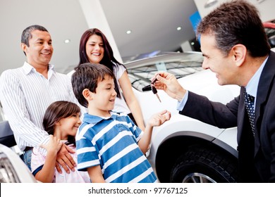 Family Buying A New Car And Getting The Keys From Salesman