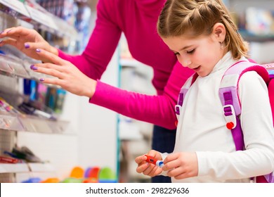 Family Buying School Supplies In Stationery Store, Little Girl Looking At A Fountain Pen