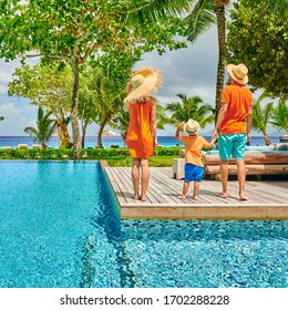 Family By Poolside, Young Couple With Three Year Old Toddler Boy. Resort Swimming Pool At Mahe, Seychelles.