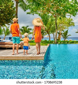 Family By Poolside, Young Couple With Three Year Old Toddler Boy. Resort Swimming Pool At Mahe, Seychelles.