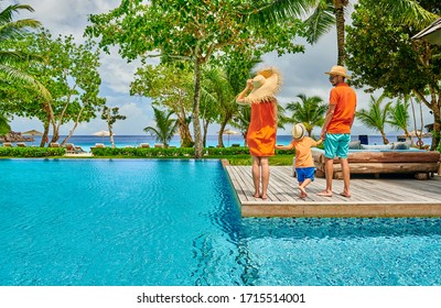 Family By Poolside, Young Couple With Three Year Old Toddler Boy. Resort Swimming Pool At Mahe, Seychelles.