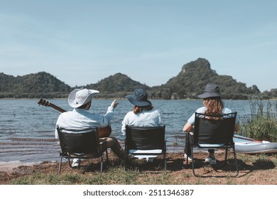 Family camping by a lake, raising their bottles in a toast appears to be a camping trip a guitar, suggesting a day filled with music enjoyment in nature holiday trip.  - Powered by Shutterstock