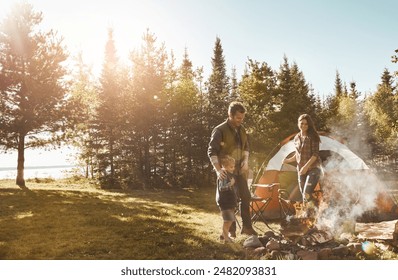 Family, camping and relax with smoke in nature by tent on grass field for outdoor vacation, holiday or weekend. Father, mother and son standing by campfire for summer getaway in sunshine at forest - Powered by Shutterstock