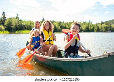 Family In A Canoe On A Lake Having Fun