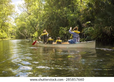 Family canoe ride down a beautiful tropical river