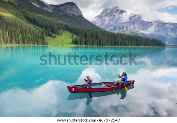 family canoeing on emerald lake\
