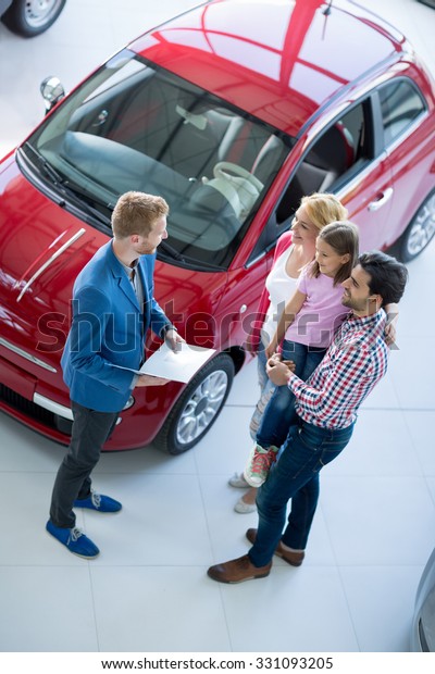 family with car\
dealer in car dealership\
saloon
